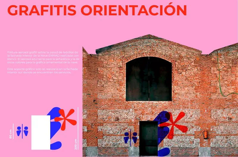 Wayfinding graffiti in red and blue on the brick walls of Matadero